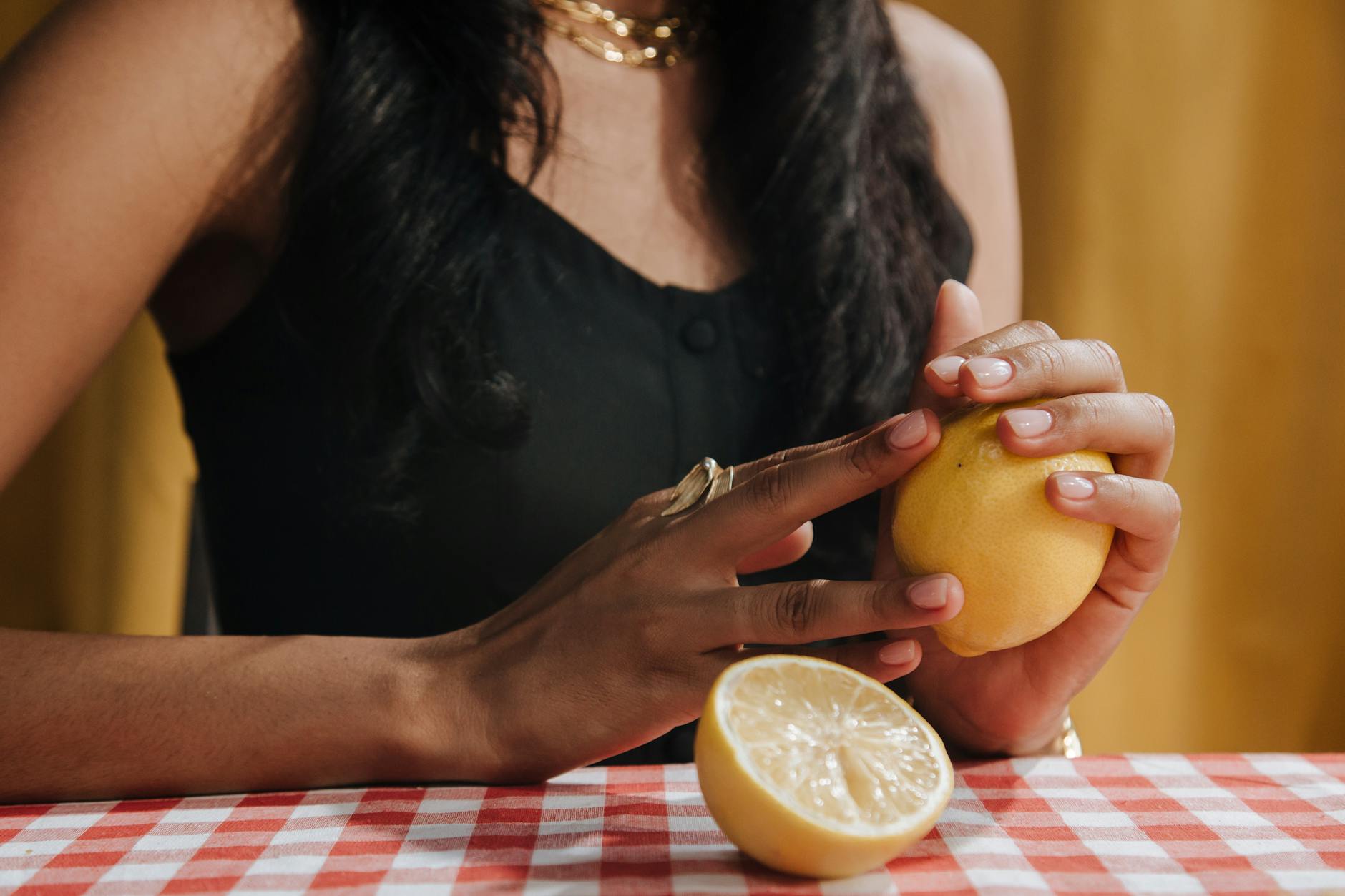 A blue vibrator surrounded by flowers and citrus on a bright yellow background